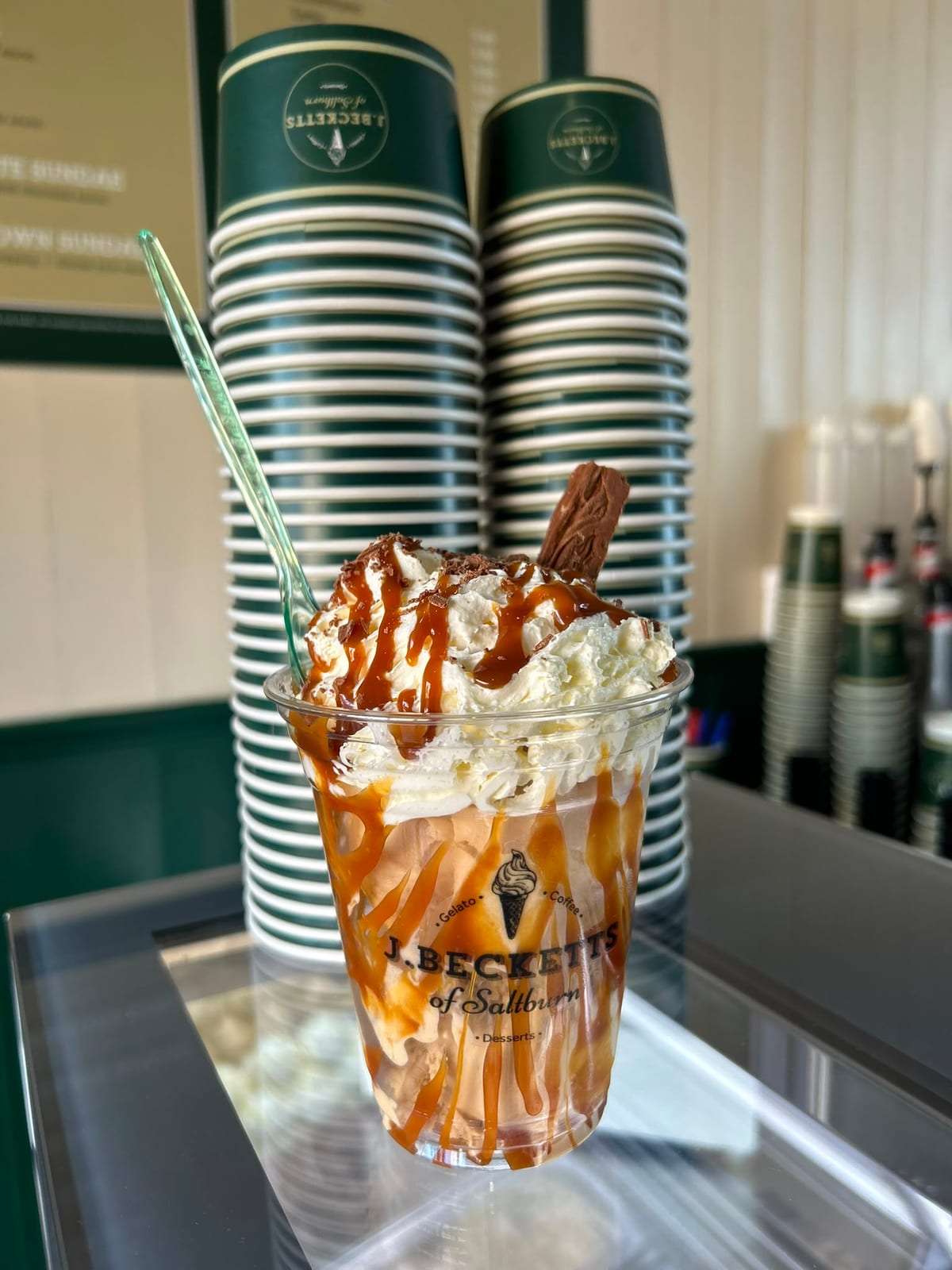 A dessert topped with cream, caramel sauce and a Flake on the J.Becketts counter