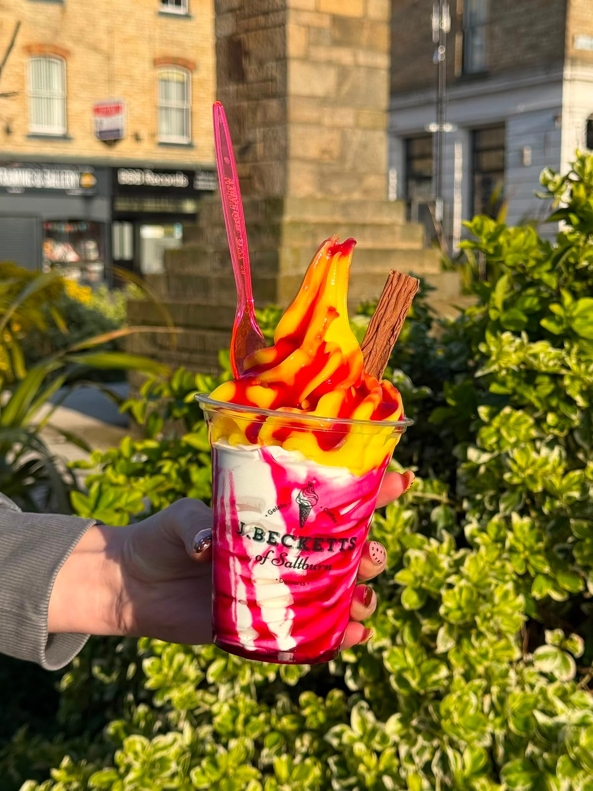 A lemon top sundae with a Flake and raspberry sauce, held up on Station Square, Saltburn